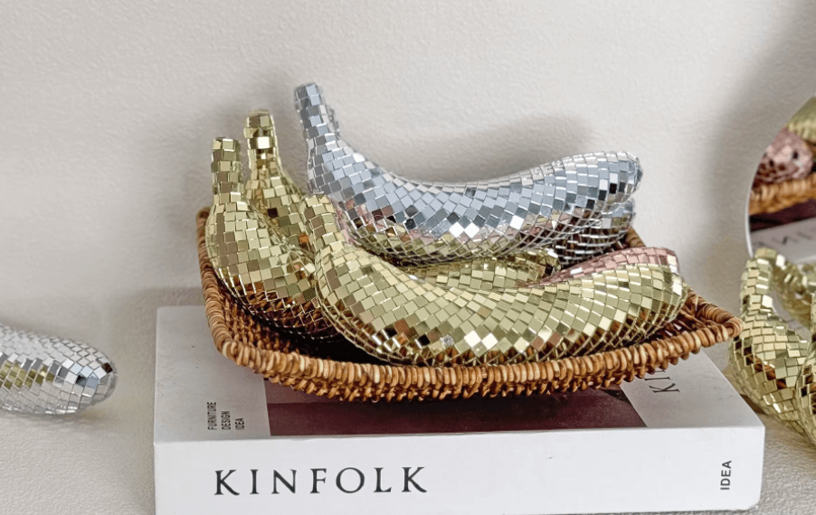 Reflective disco banana decor set in a basket; stylish home accessory with silver and gold mosaic tiles, perfect for modern interiors.